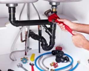 plumber repairing sink pipes
