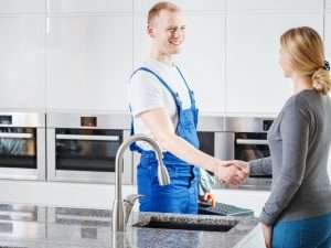 friendly plumber with grateful customer