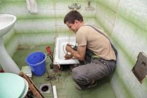 plumber working on a bathroom drain