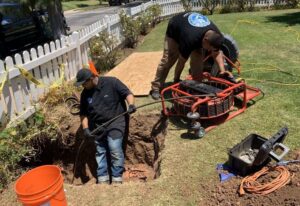 Two All Service Plumbers Technicians Fixing a Sewer