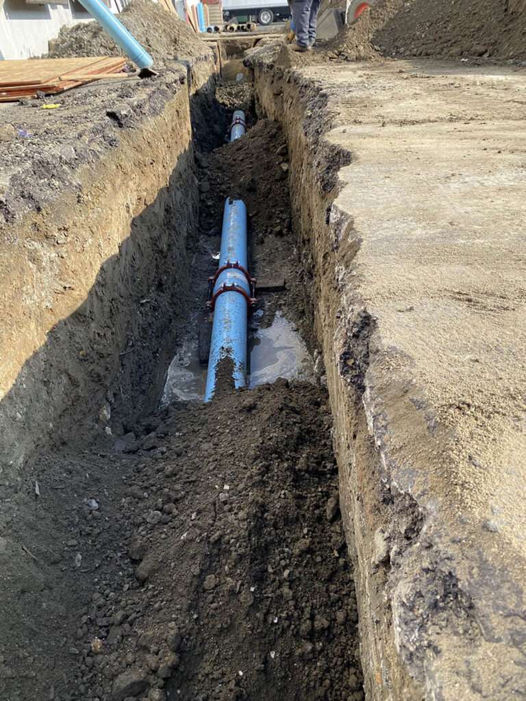 New underground water line laid in a narrow trench