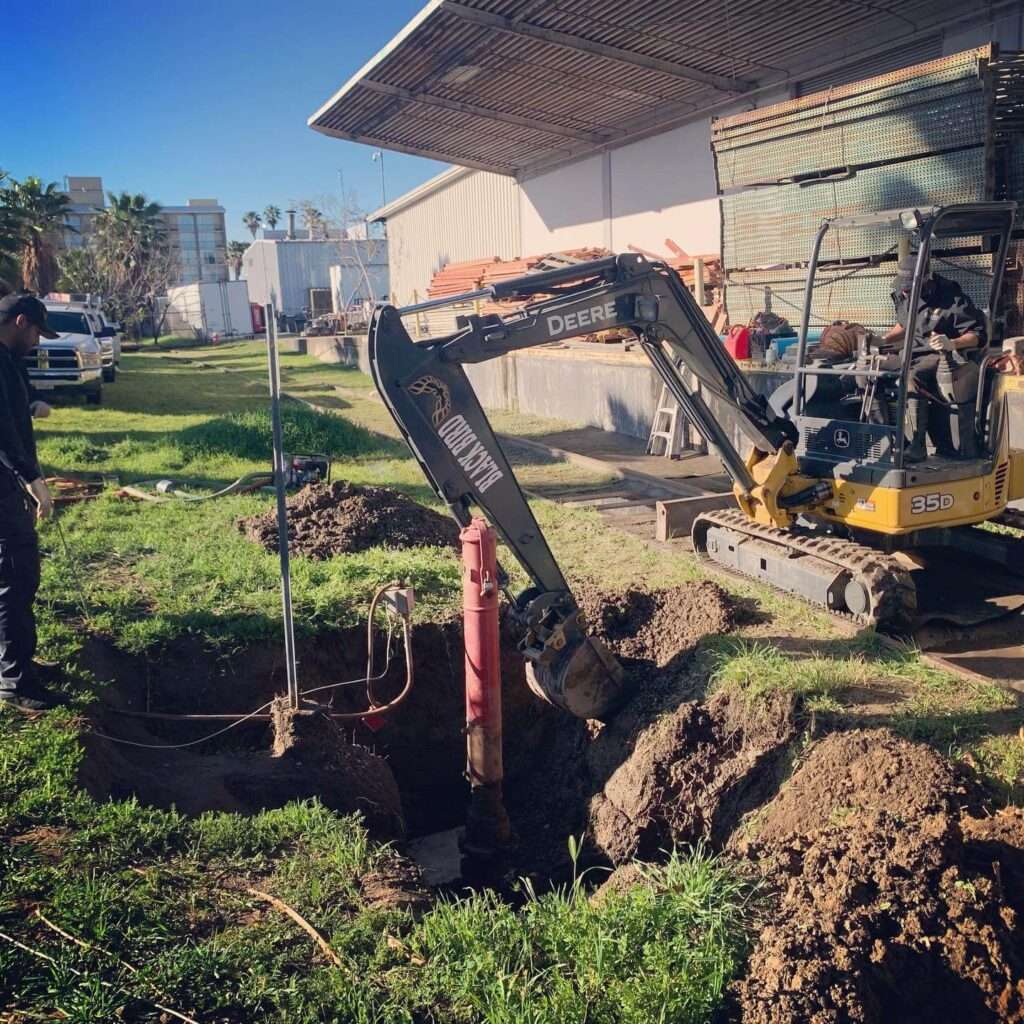 Mini excavator digging to reach an underground fire service line