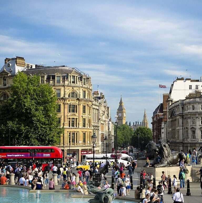 Crowds and red buses outside the Palace of Westminster in London